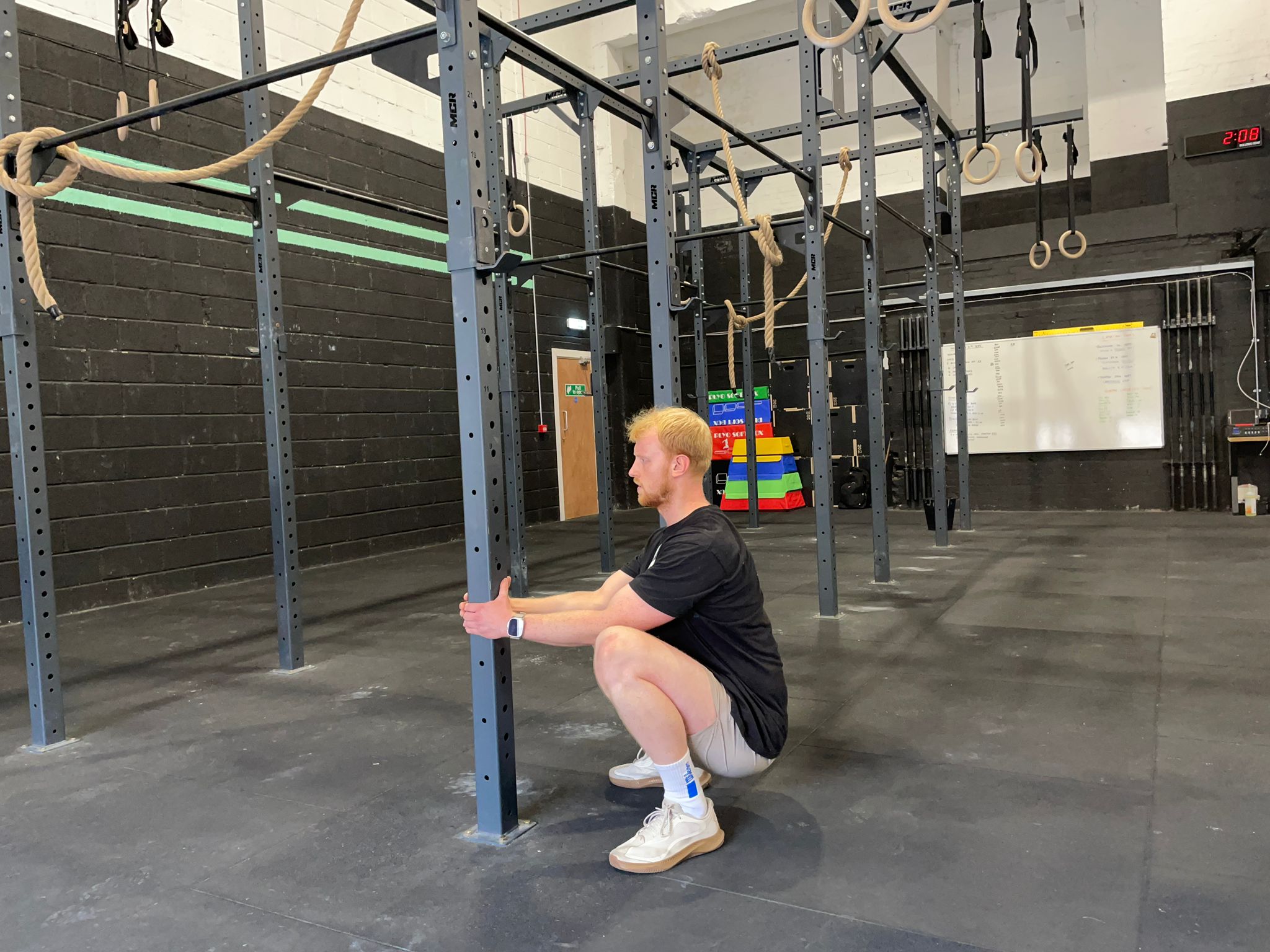 El escritor de fitness Harry Bullmore toma una posición en cuclillas