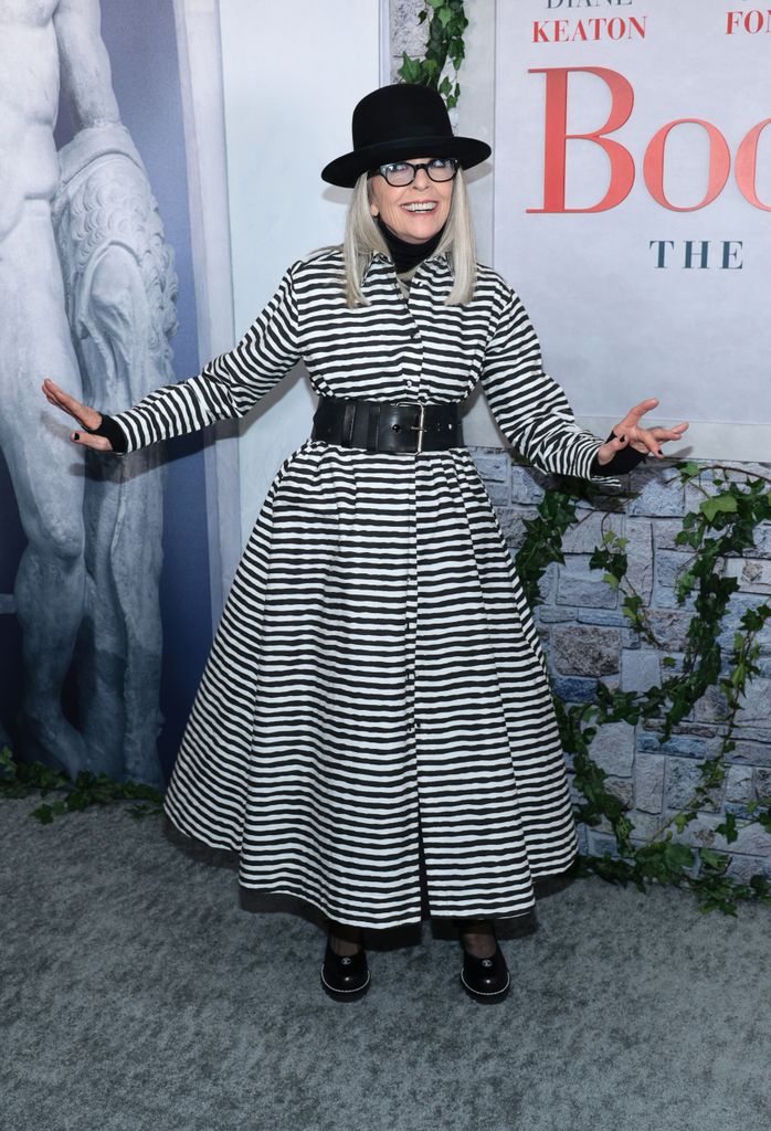 Diane Keaton sonríe con un vestido a rayas en blanco y negro con un sombrero