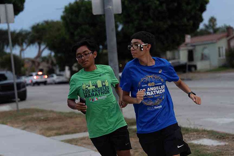 Joshua Pérez, Derecha y Jayden Chamale, miembros del Huntington Park Run Club, Huntington Park, California, de 17 años, 2025 corrieron en un vecindario en 2025. (AP Photo / Jae C. Hong)