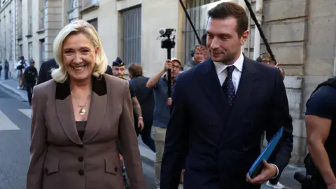 Reuterers sonríe Sea Le Pen y Jordan Bardella camina por la calle