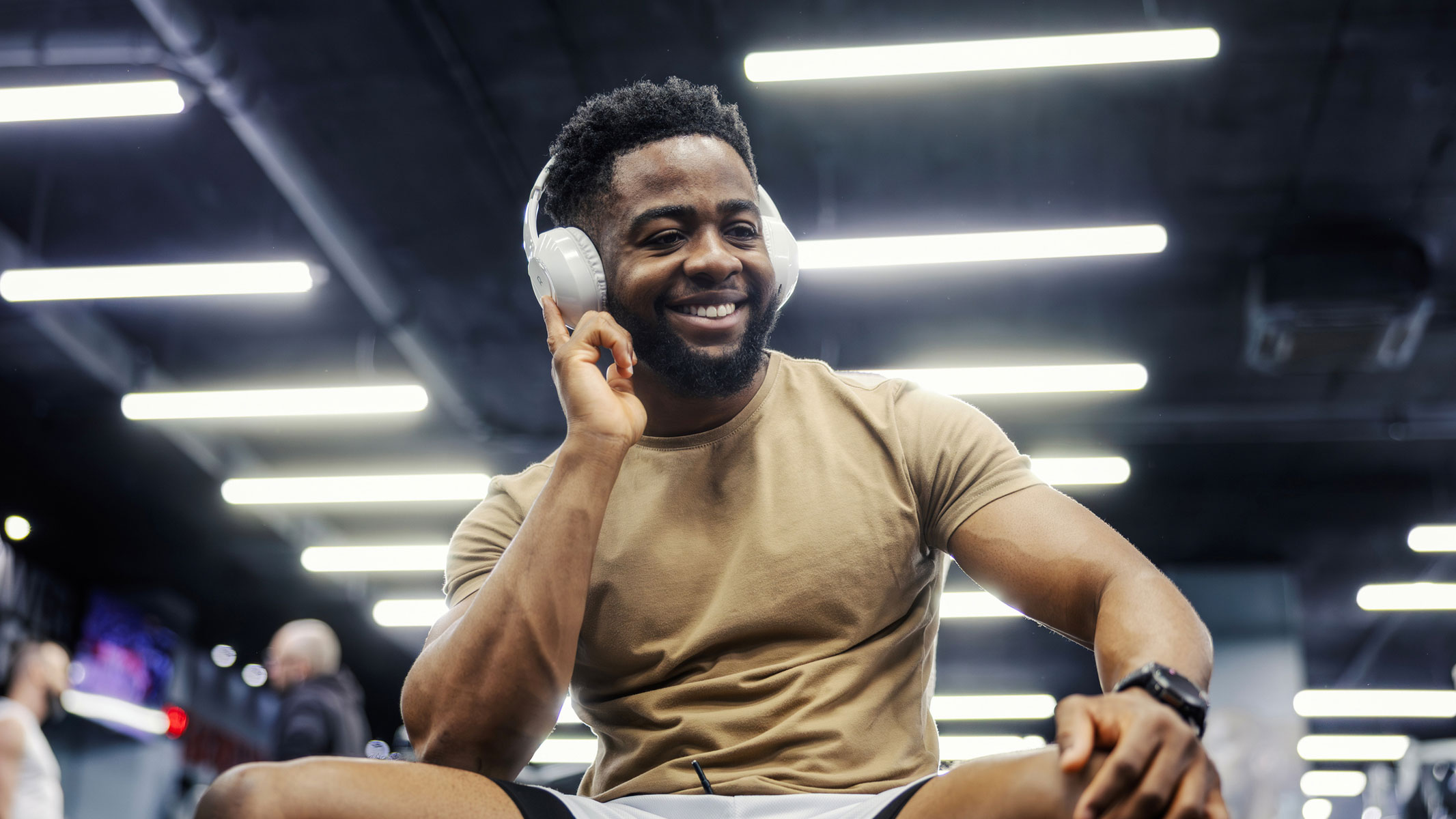 Una foto de un joven escuchando sus auriculares en el gimnasio.
