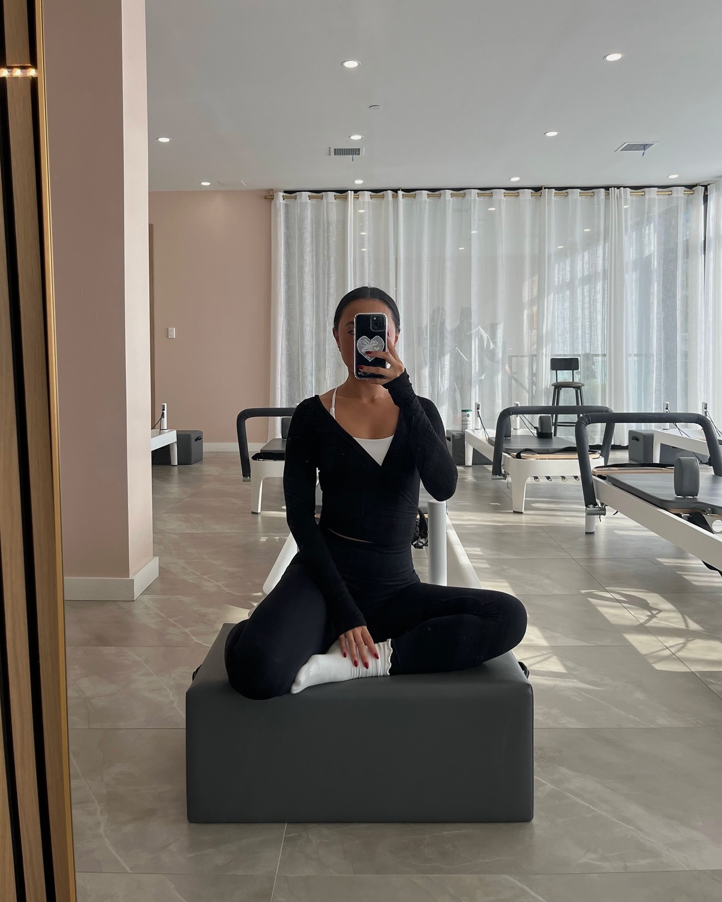 Mujer de negro entrenando en clase de pilates