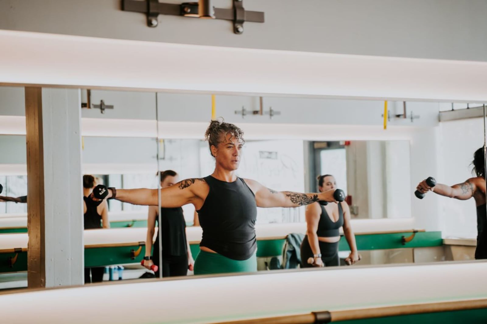 Los participantes realizan ejercicios de la parte superior del cuerpo con pesas de mano durante una clase grupal de fitness en Space Three en Dayton. SUBVENCIÓN OTORGADA