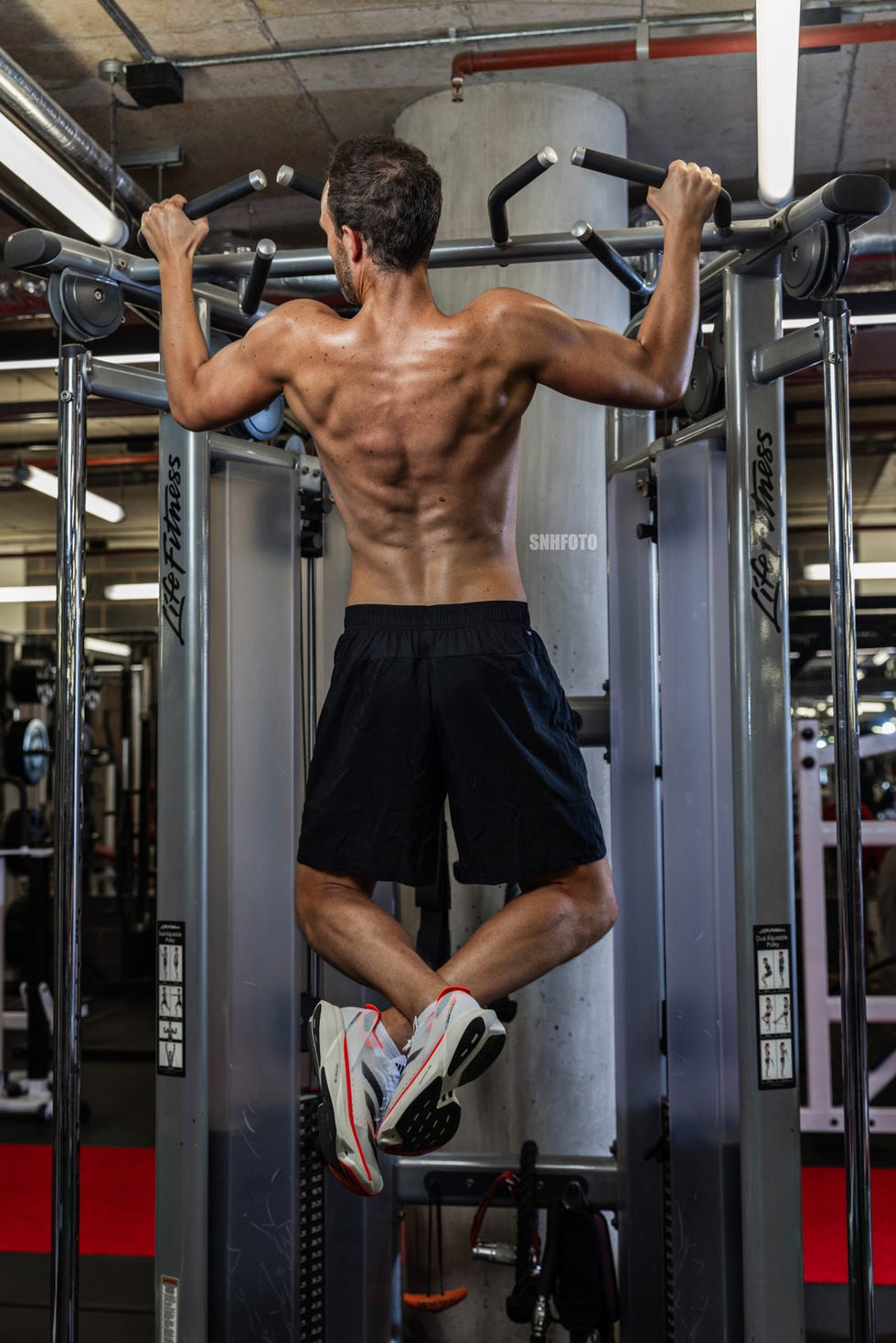 una persona realizando dominadas en una máquina de gimnasio