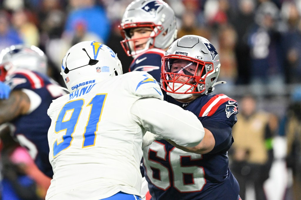 El equipo ofensivo de New England Patriots Will Campbell (66) se enfrenta al final defensivo de Los Angeles Chargers Da'shawn Hand (91) durante la segunda mitad del juego de la Ronda Wild Card de la AFC en el estadio Gillette.