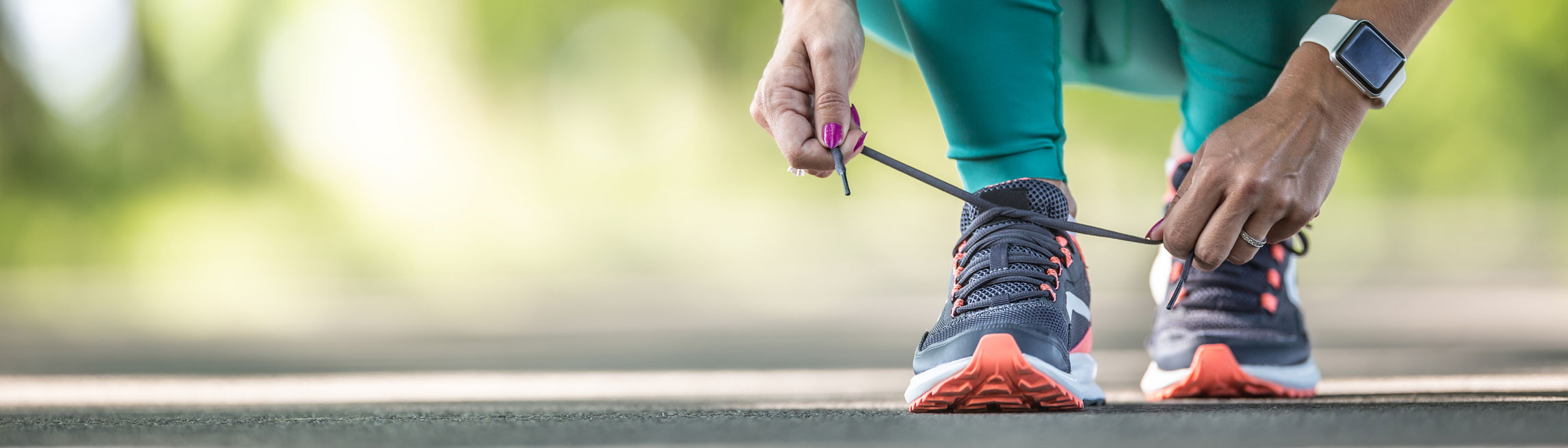 Primer plano de una mujer atando sus zapatos para correr