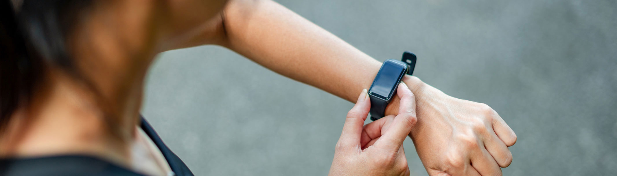 Primer plano de una mujer joven comprobando el reloj de fitness mientras hace ejercicio