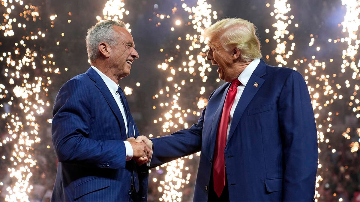 Donald Trump le da la mano a Robert F. Kennedy Jr. en un mitin en Glendale, Arizona
