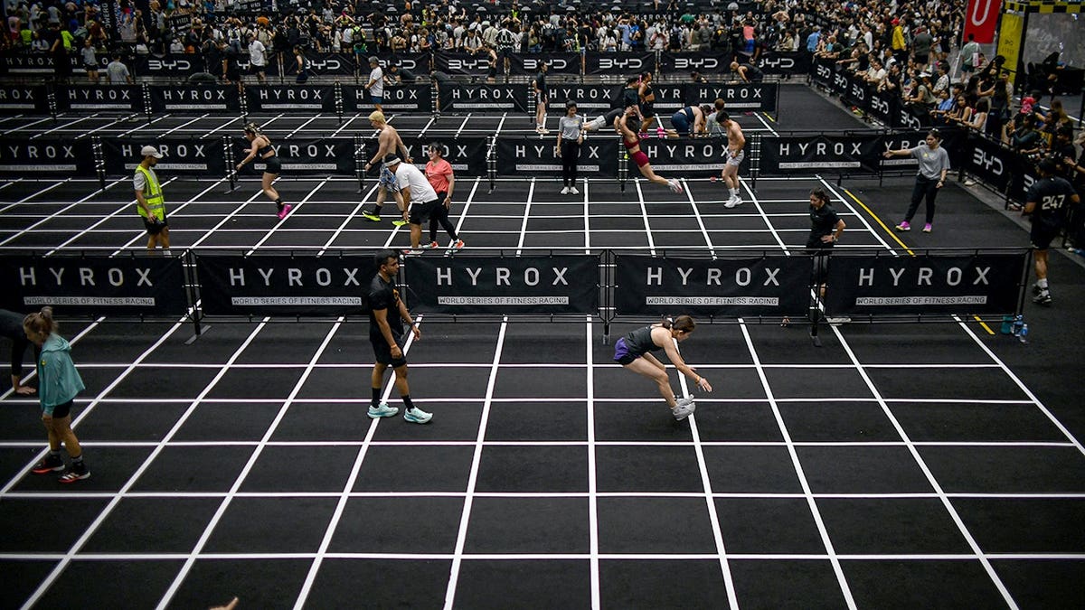 Los competidores realizan saltos de longitud en la competencia de fitness Hyrox en Bangkok